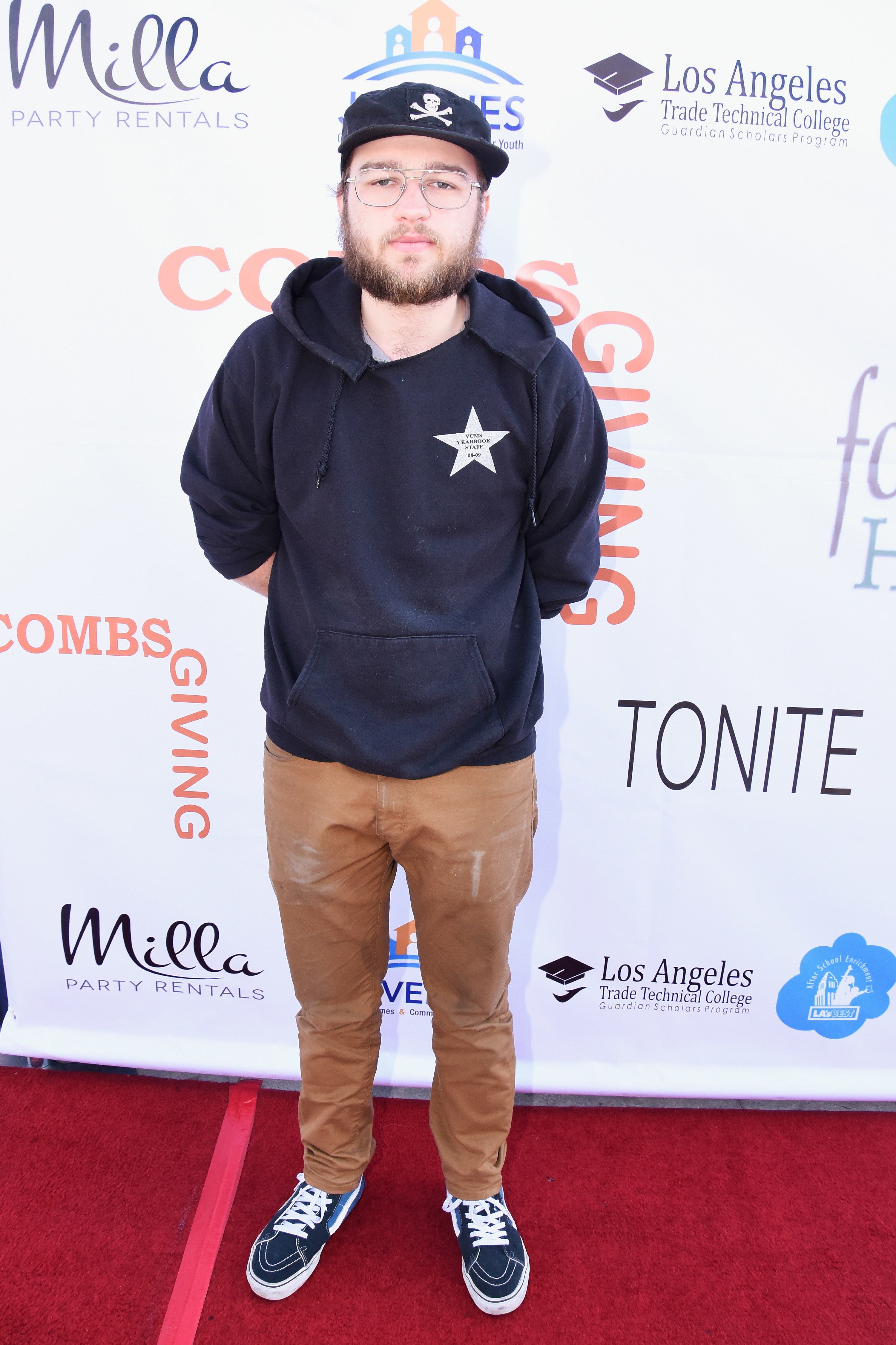 Angus dressed casually in a hoodie, baseball cap, and sneakers on the red carpet
