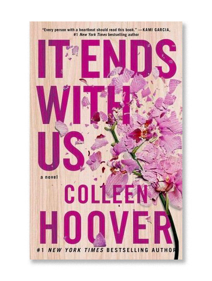 Colleen Hoover&#x27;s &quot;It Ends With Us&quot; cover. It is a light woodgrain and a flower laying on it, looking crushed and torn.