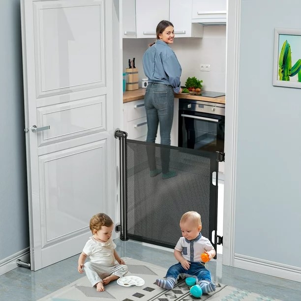 Two babies sitting on one side of the gate