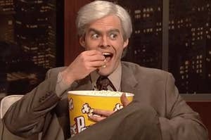 Bill Hader eats popcorn out of a bucket 