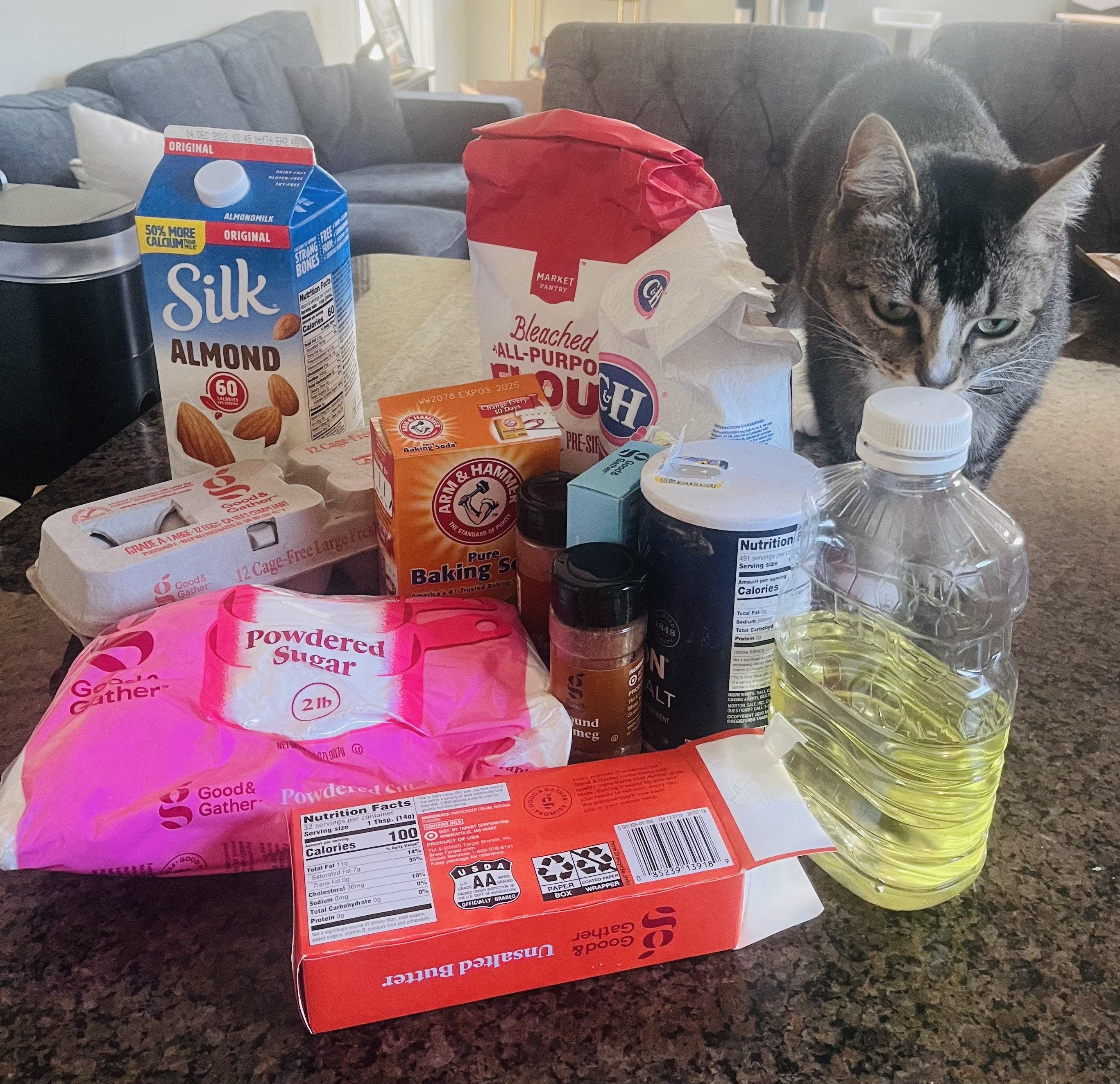 the ingredients on a table and a cat sniffing them