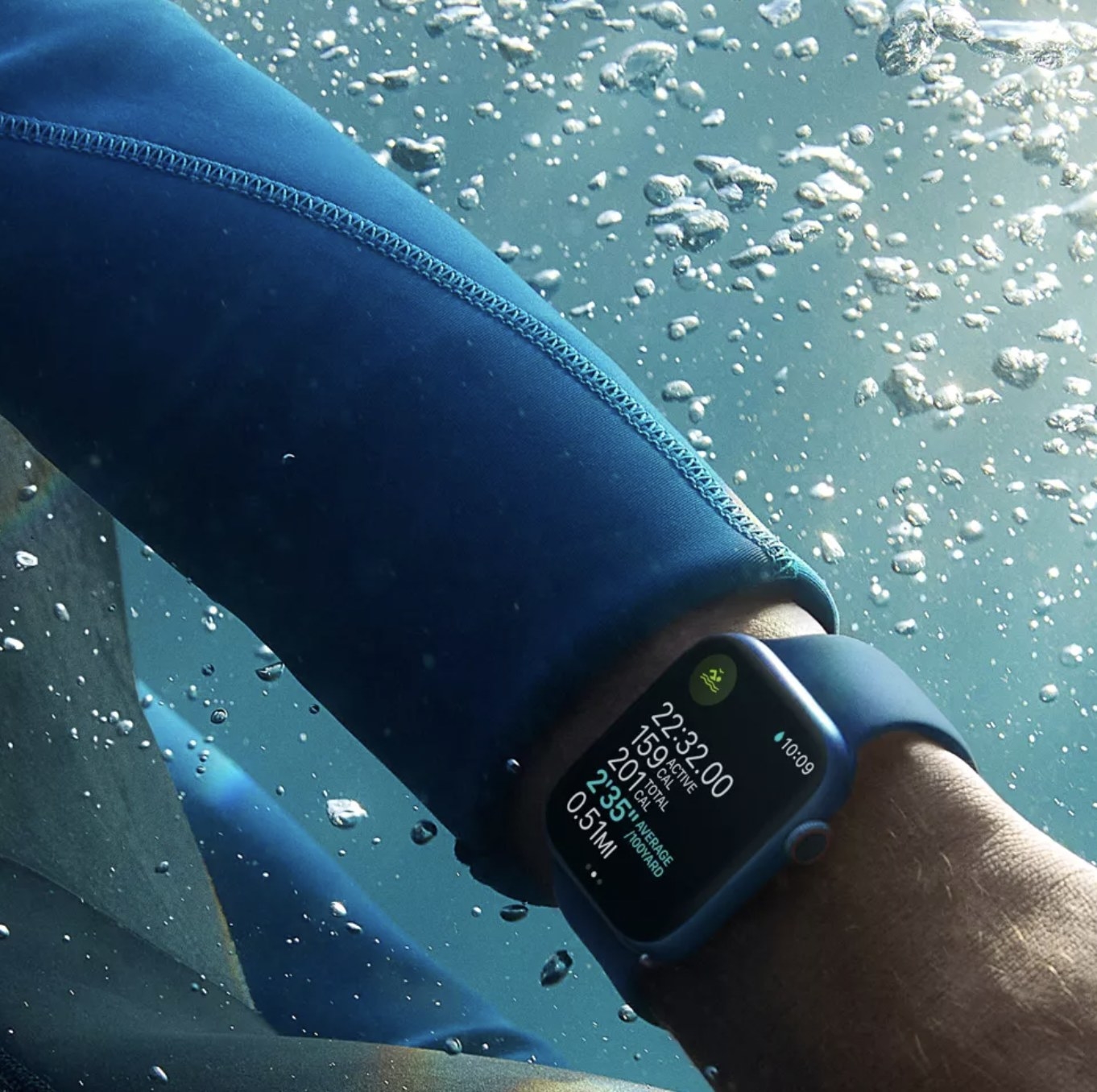model wearing Apple Watch with blue strap while swimming in water