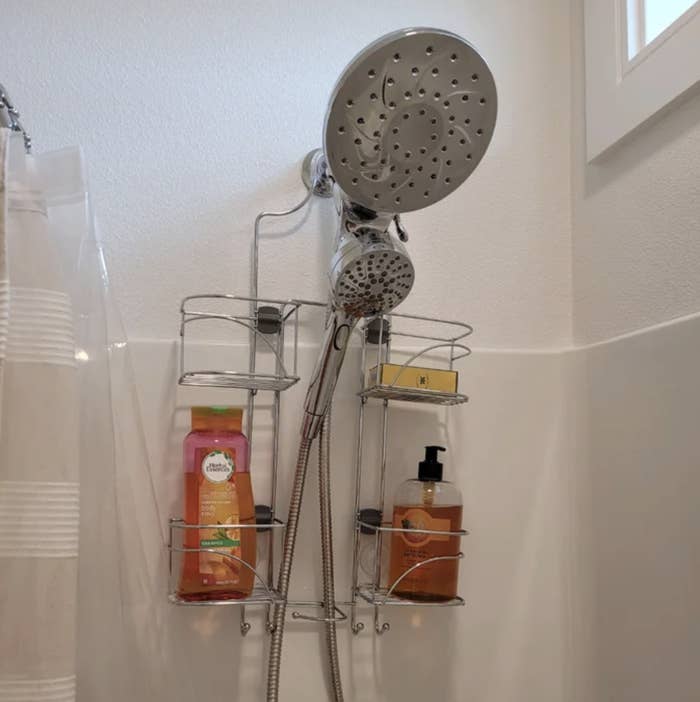 the shower caddy hanging over a shower head with bottles of shampoo and conditioner in it