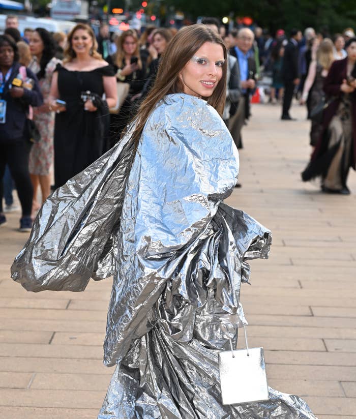 Julia wearing a silvery garment that looks like a trash bag