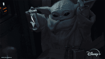 a gif of baby yoda excited with his arms up