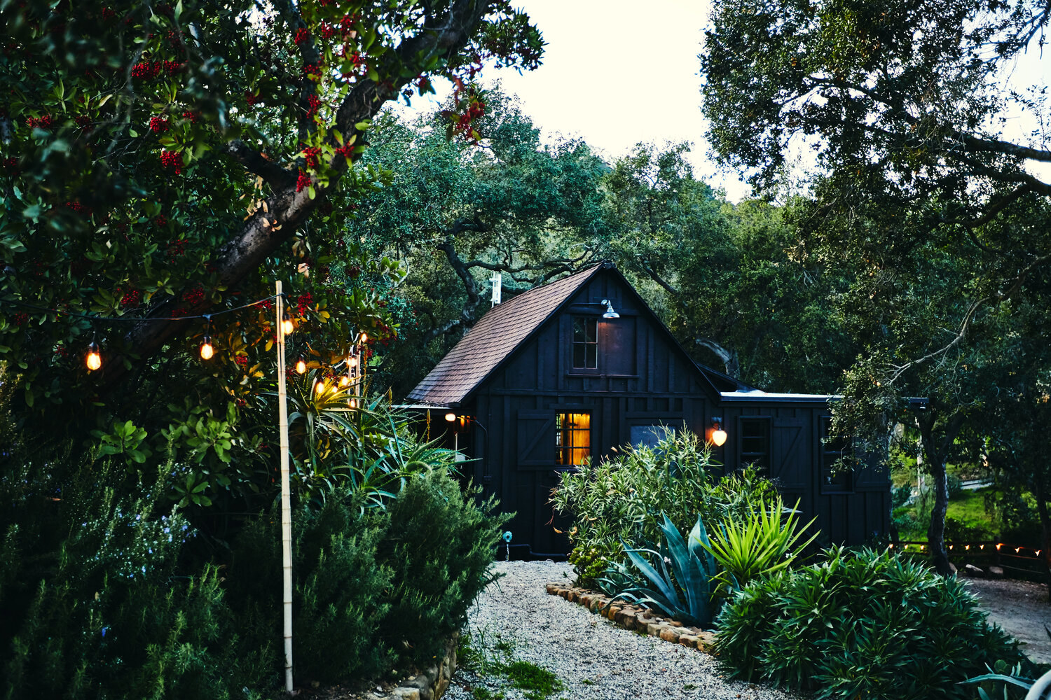 exterior shot of the all black house with gravel pathways and gardens