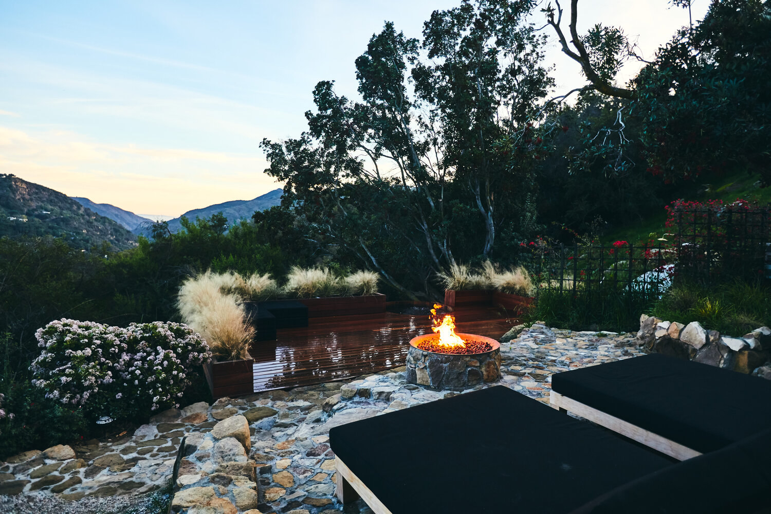 wide angle of the cedar deck with soaking tub, fire pit, and lounge chairs