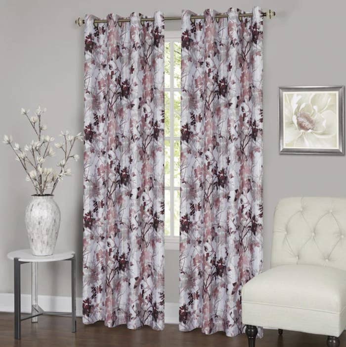 Window framed with two grommet panels in white with pink and purple floral pattern