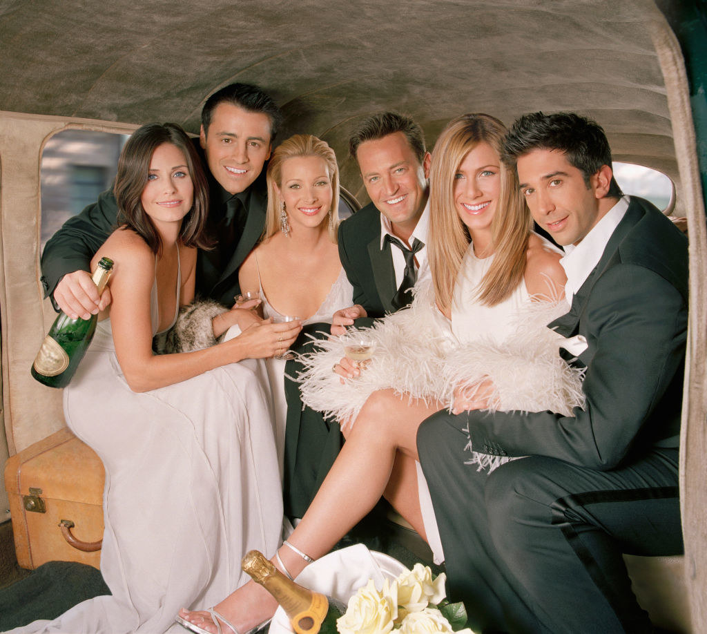 the cast of friends posing with champagne