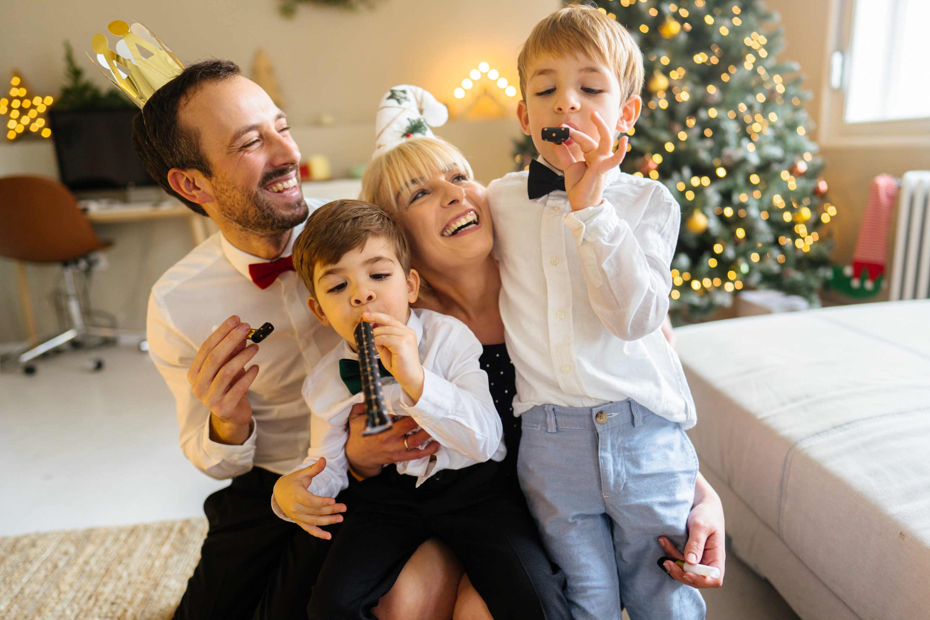 Photo of a family with two children celebrating Christmas and New Year holidays together at home