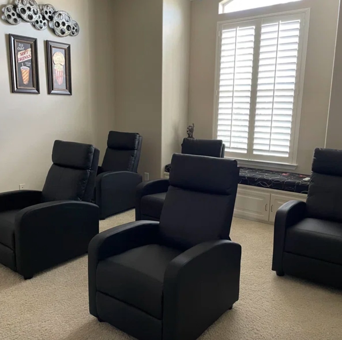 a Wayfair reviewer image of five black reclining chairs in their home theater
