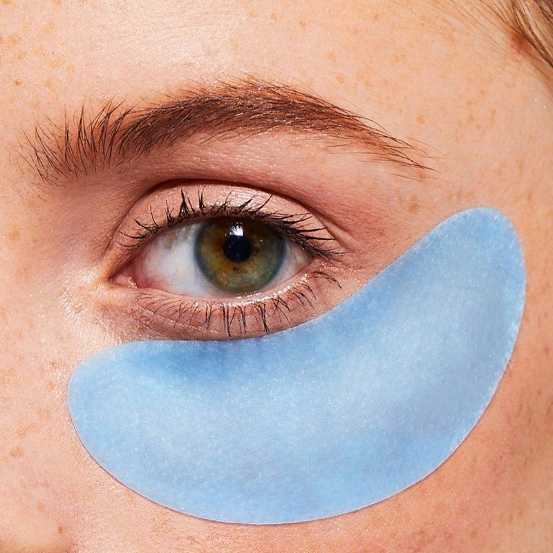 A person using a blue under-eye mask