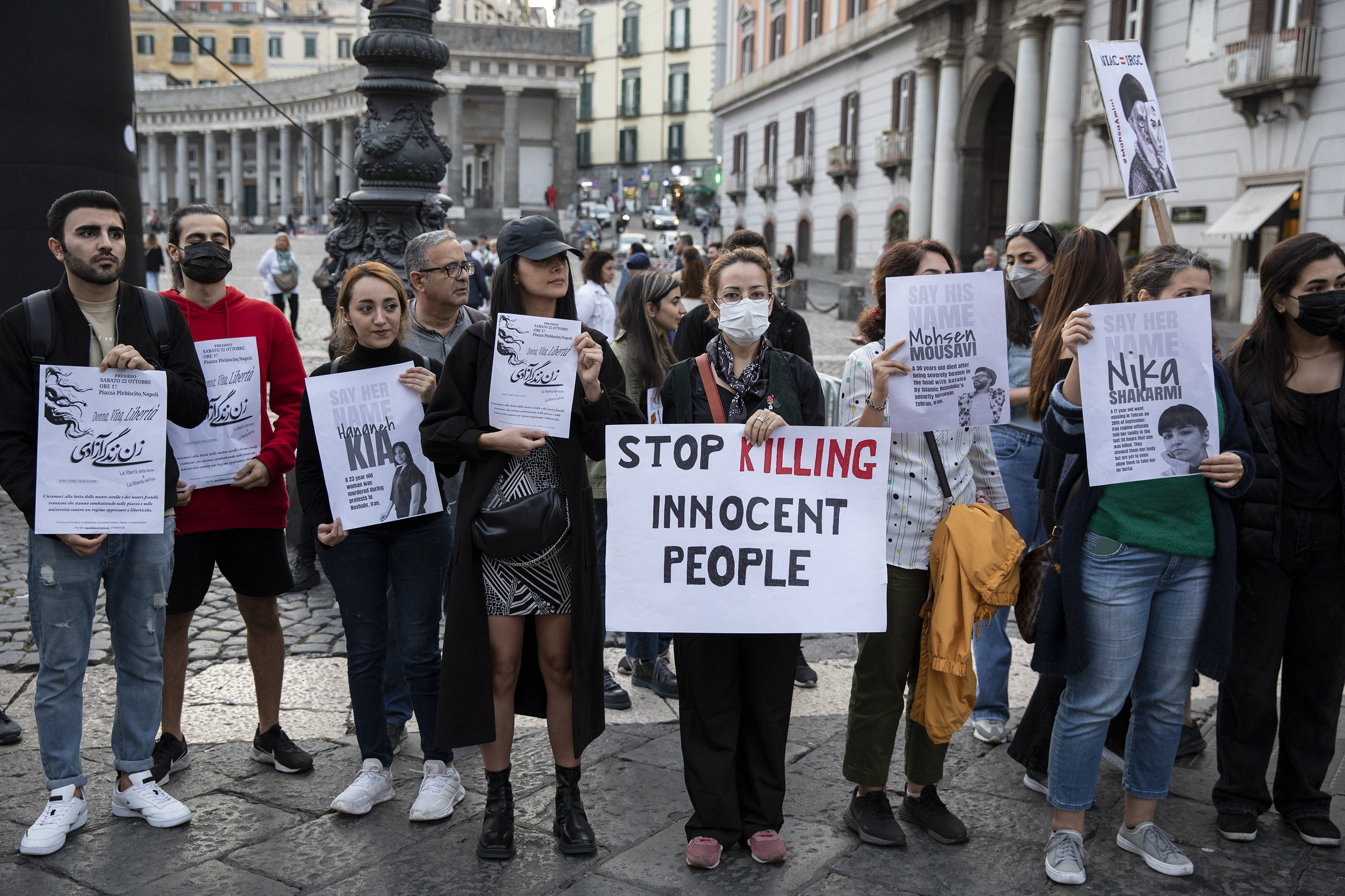 Protestors hold up signs and profiles of people who have died in police custody.