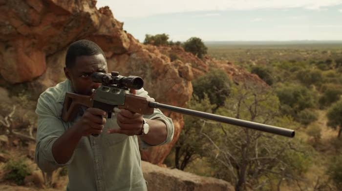 Idris Elba aiming with a gun in Beast