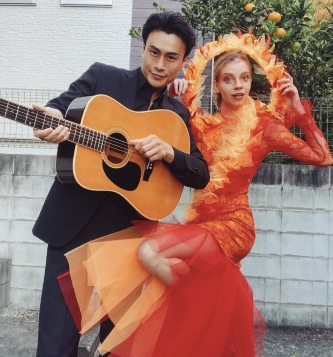 Someone dressed as Johnny Cash, holding a guitar, while another person dresses in fiery red