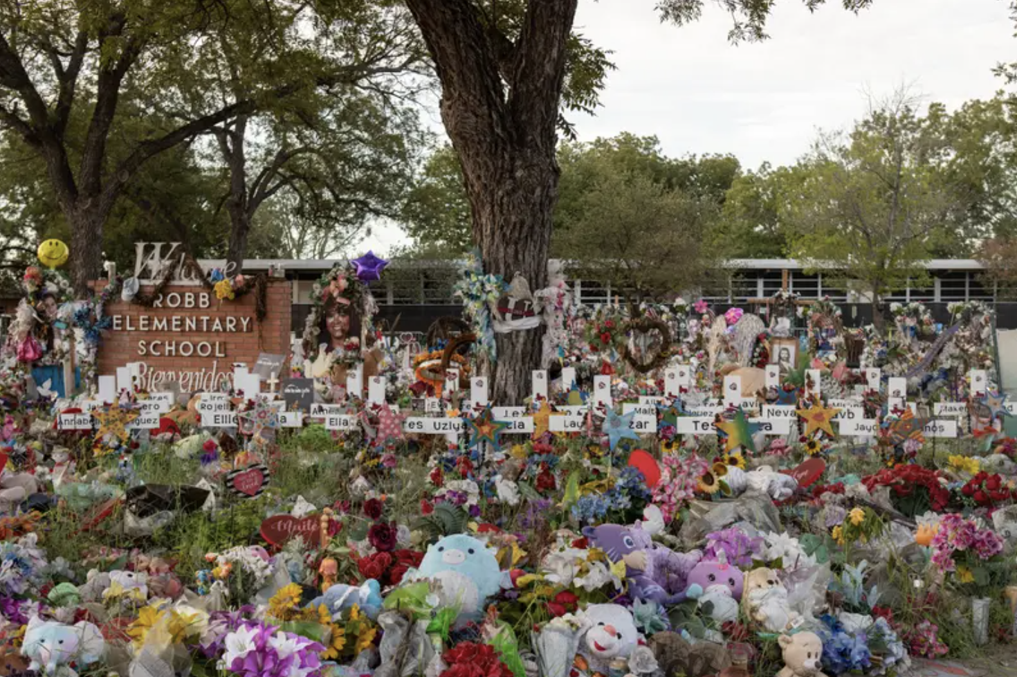 A memorial on a grass lawn filled with flowers and gifts for the student victims of the Uvalde shooting