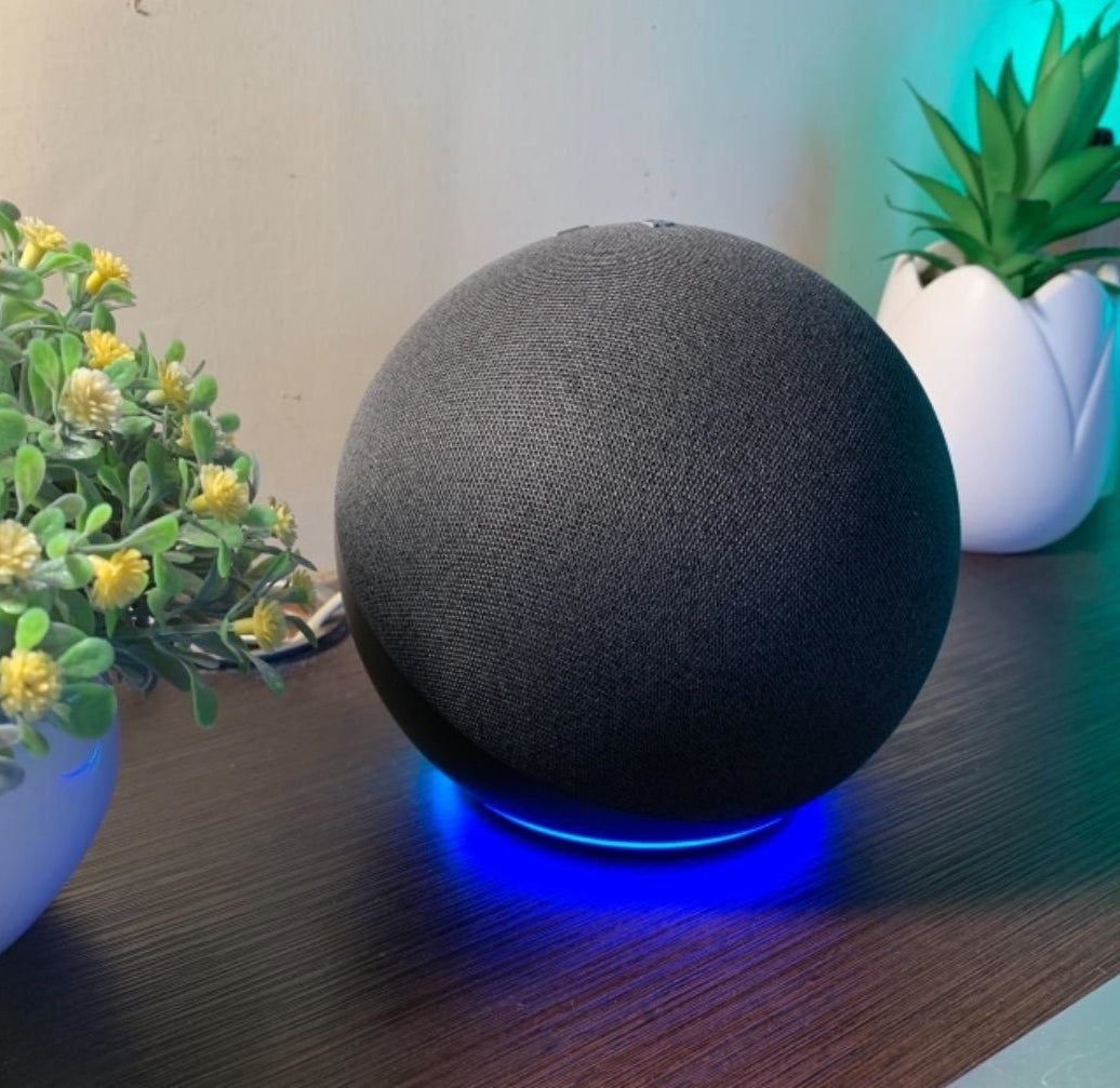 Reviewer&#x27;s black Echo sphere speaker sitting on desk with blue glow beneath