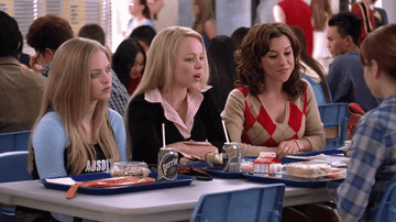 Girls sitting at a high school cafeteria table.
