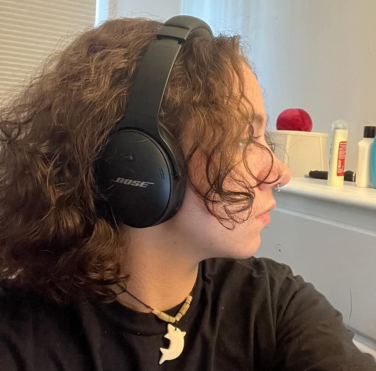 reviewer from side with black headphones over ear