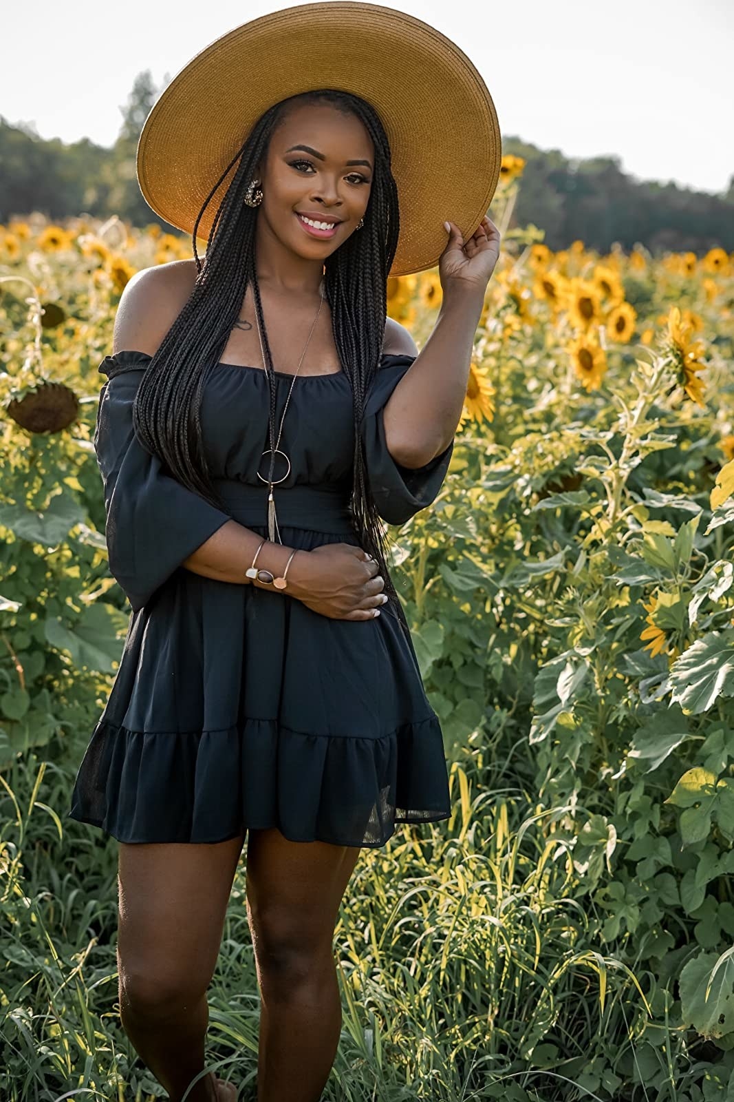Reviewer in the black dress posing in sunflower field