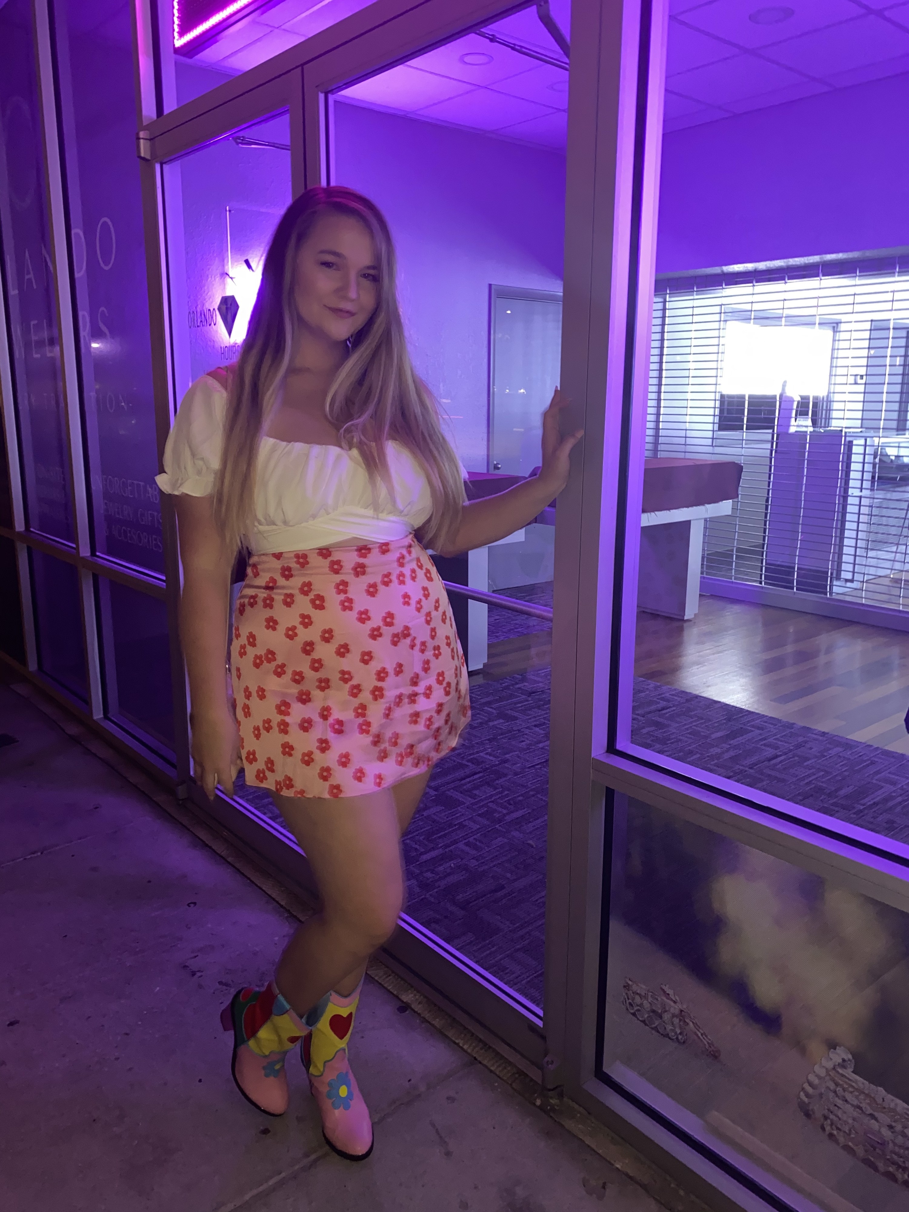 Reviewer wearing the pink floral skirt with cowboy boots