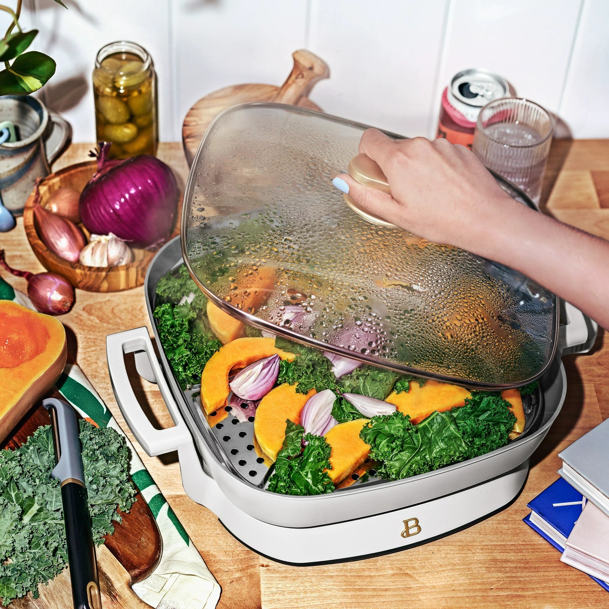 The skillet filled with food, as a person lifts the lid.
