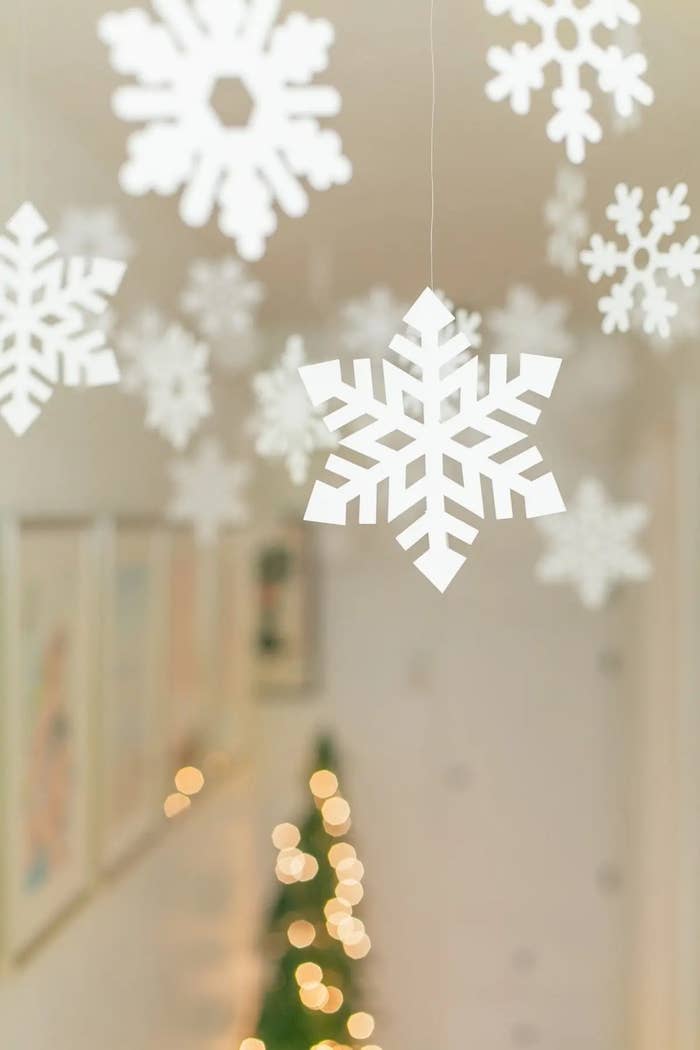 kid-friendly DIY white cut-out snowflake flurry in hallway for holiday decor