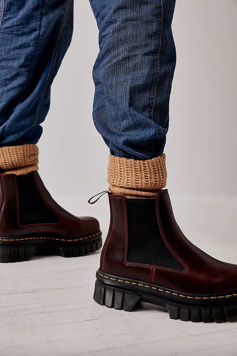 a model wearing the dark red boots with tan socks and jeans