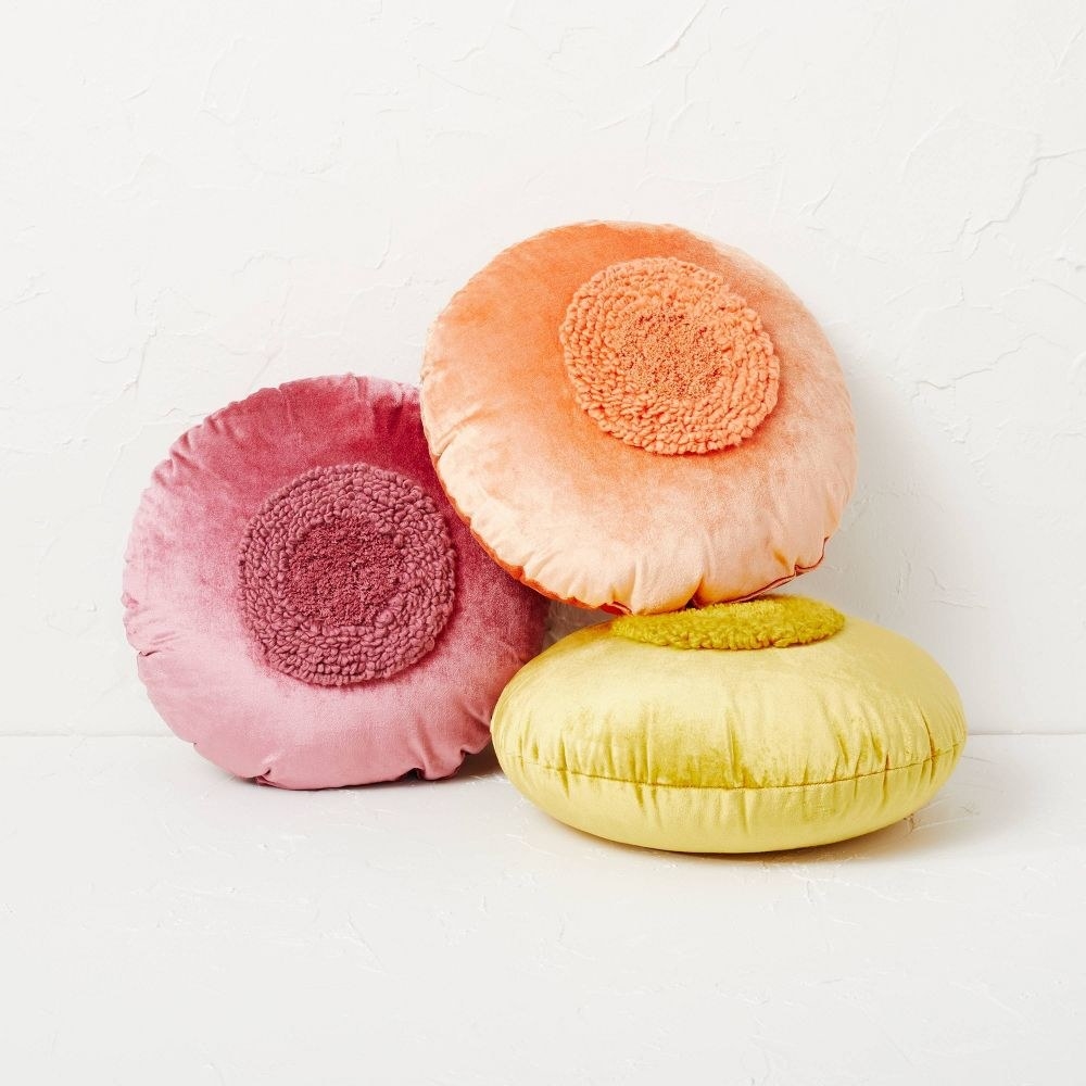 three round tufted pillows in red, orange, and yellow