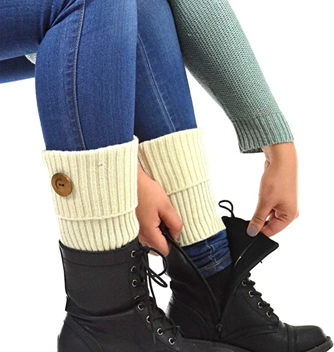 a person putting combat boots on with the leg warmers on their legs