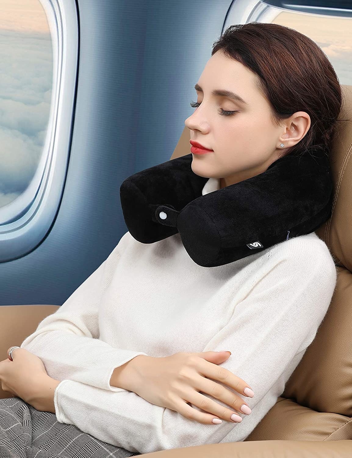 person sleeping on a plane with the pillow around their neck