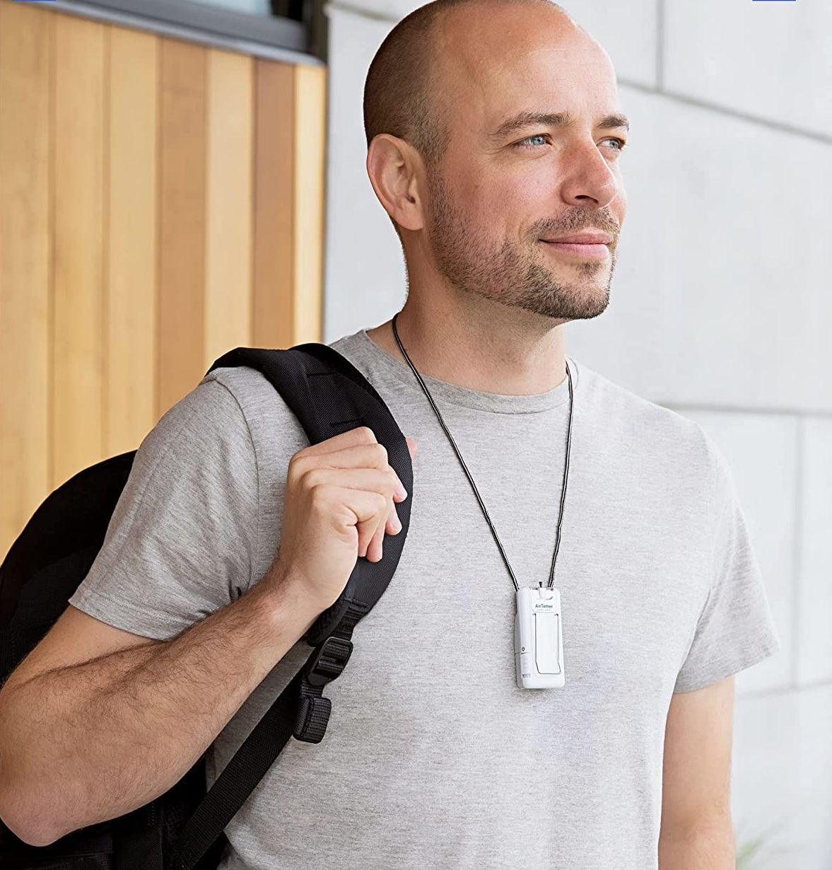 person with a strap of their backpack on and the device around their neck