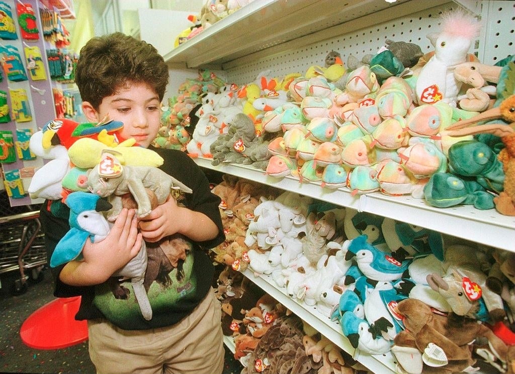 A kid holding a bunch of Beanie Babies