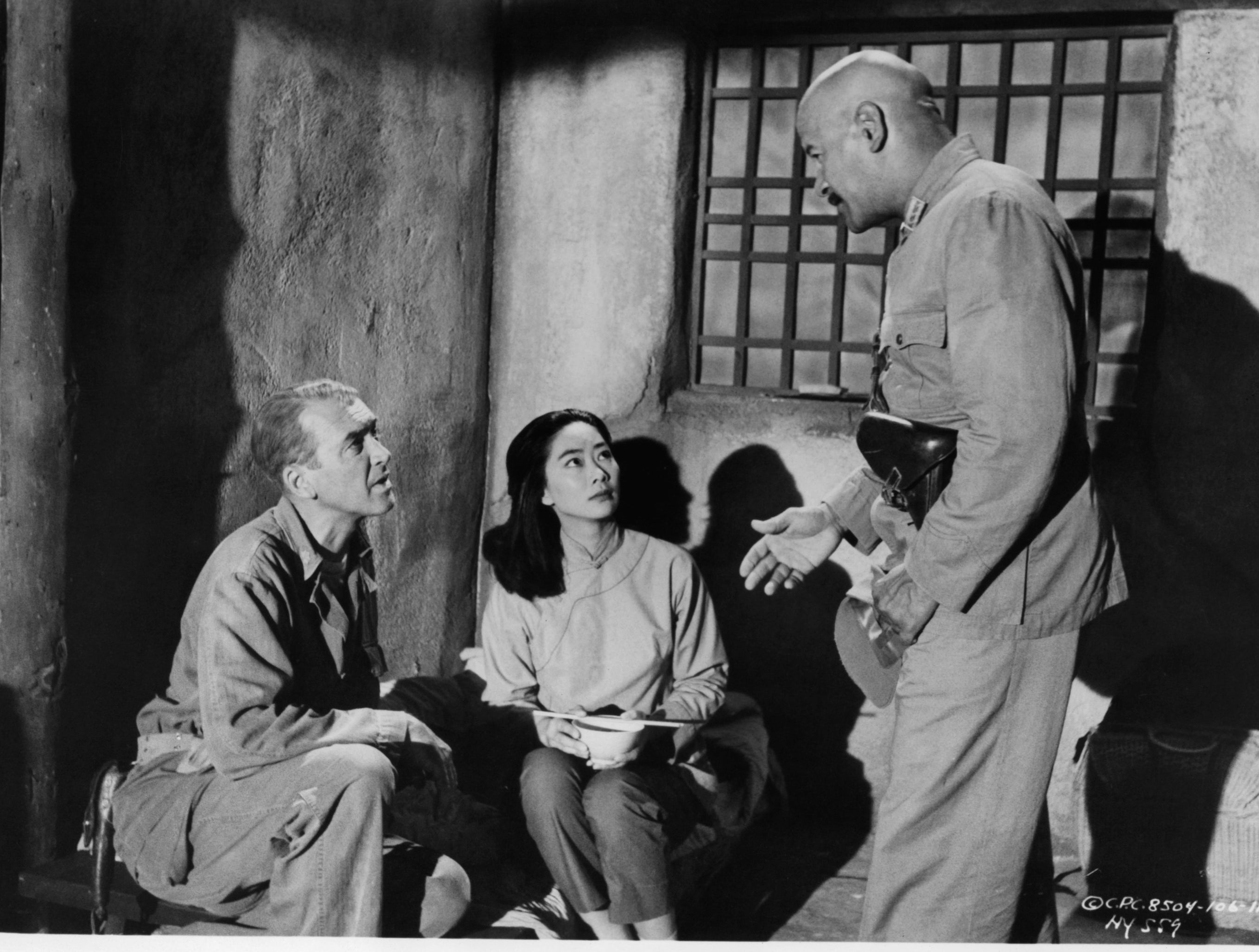 James Stewart and Lisa Lu are spoken to by unidentified man with gun in a scene from the film &#x27;The Mountain Road&#x27;, 1960