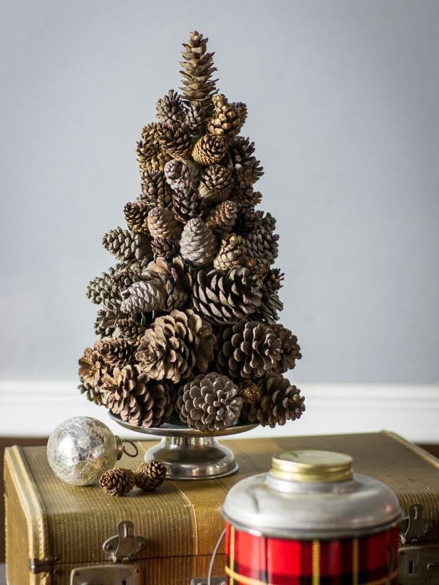 tree made of pine cones on top of suitcase with ornament beside it