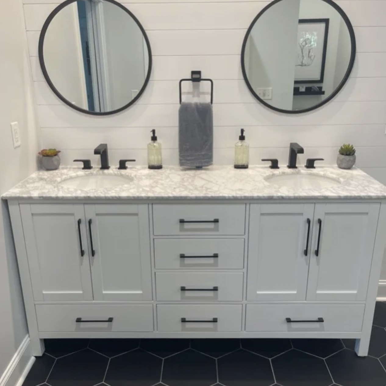 reviewer&#x27;s photo of the white double vanity with black faucets