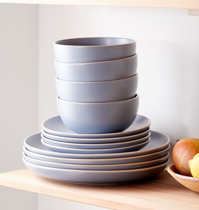 four bowls and eight plates stacked on a shelf