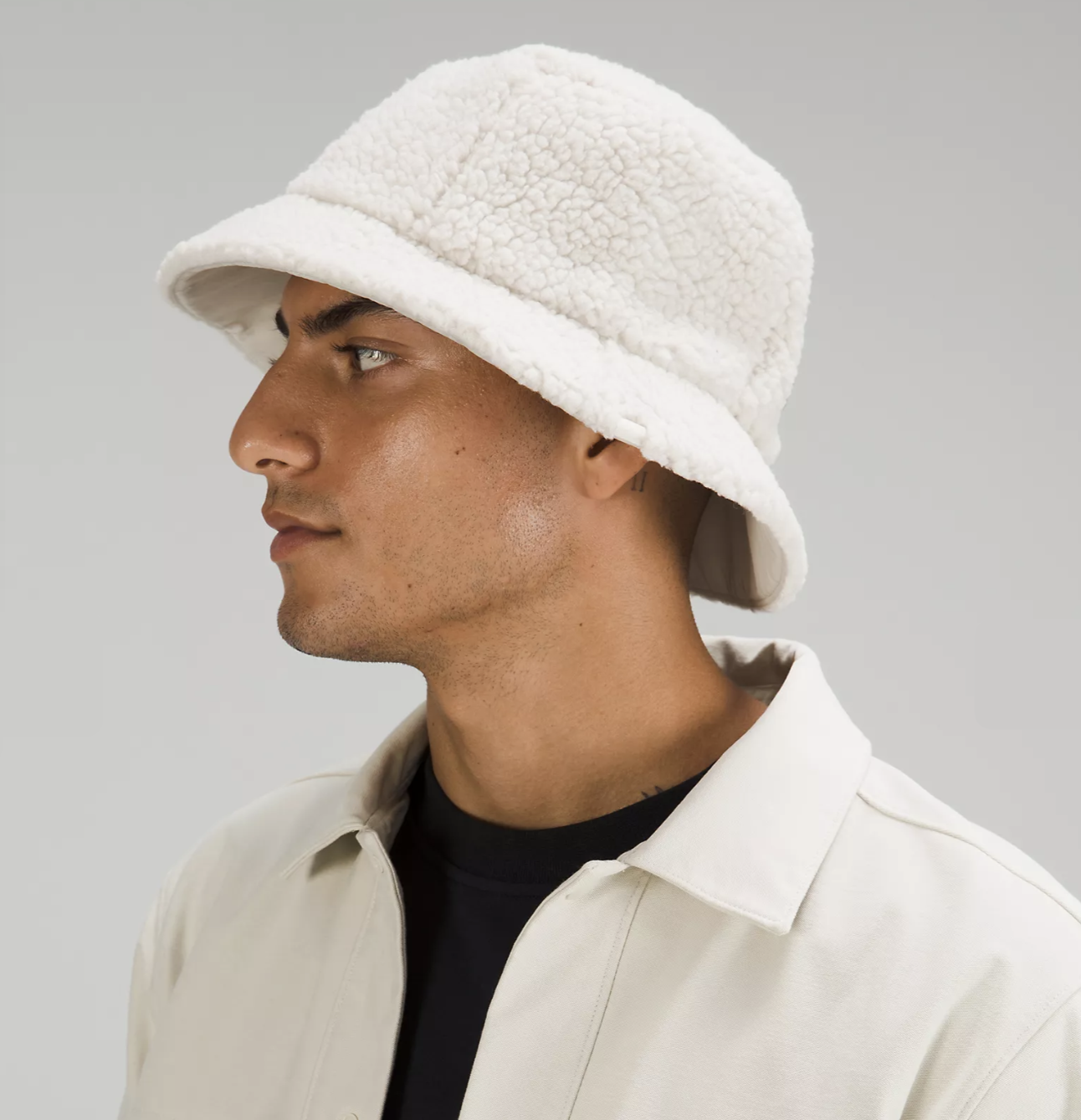 a person wearing a bucket hat in front of a plain background
