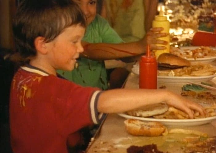 A boy grabbing fries off his plate