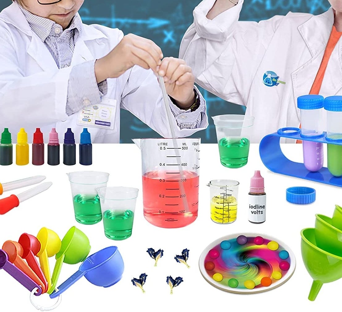 two kids wearing lab coats playing with the science kit