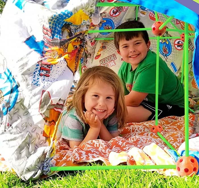 two kids in a fort outside