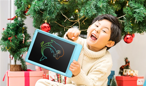 a kid holding up the writing tablet in front of a christmas tree