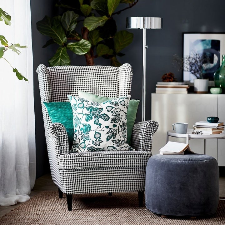 a black and white checkered armchair with colorful throw pillows on it