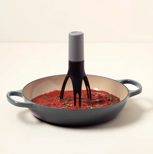 an automatic pan stirrer in a pan of tomato sauce