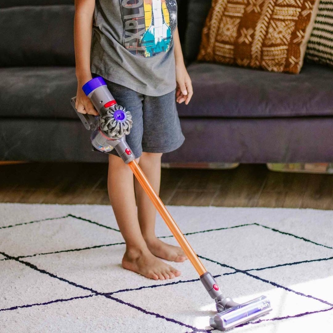 a child using the dyson toy vacuum