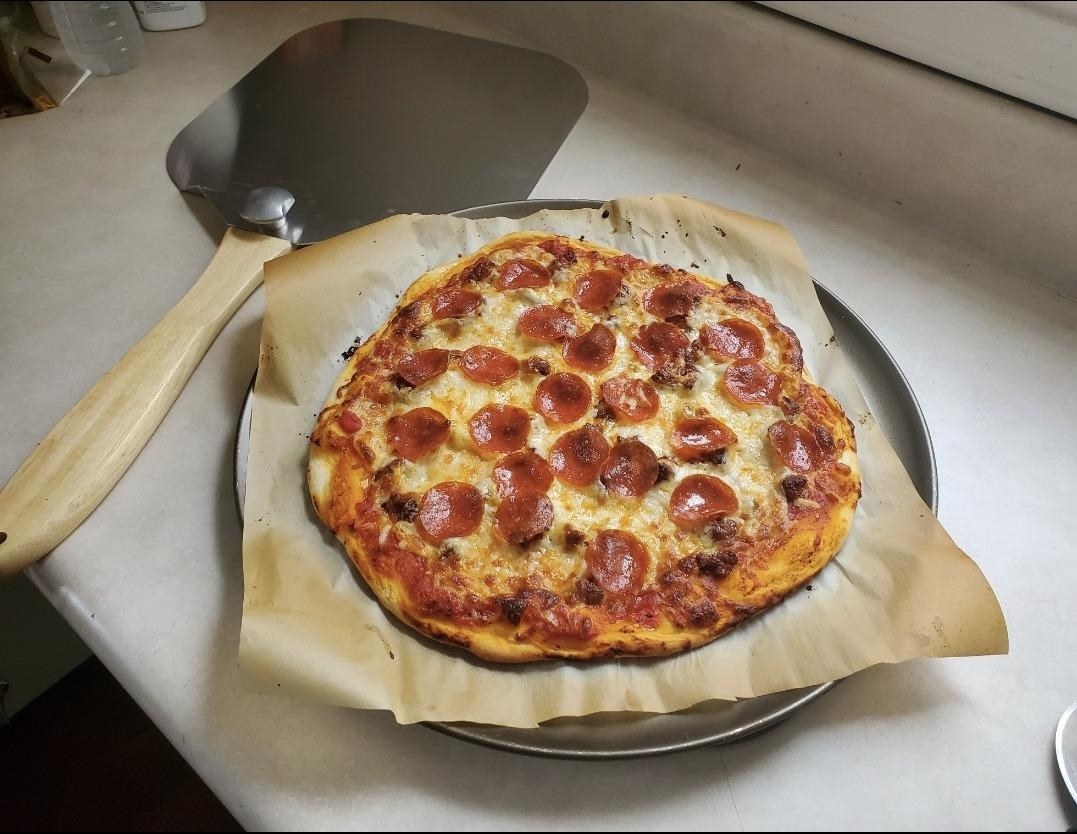Reviewer image of pizza peel next to homemade pizza