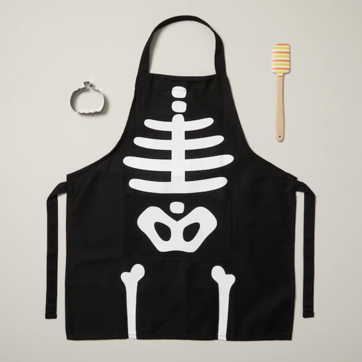 the apron, spatula, and cookie cutter against a plain background