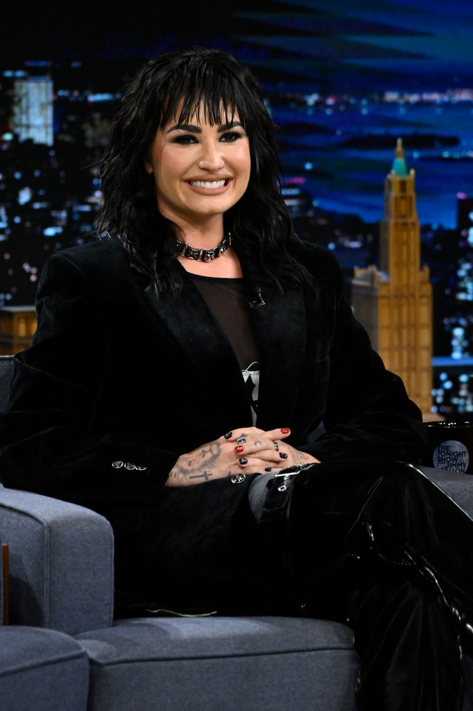 Demi smiling and sitting down for an interview