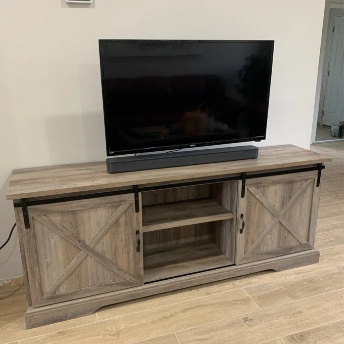 Reviewer&#x27;s photo of the beige entertainment center supporting large flat-screen TV