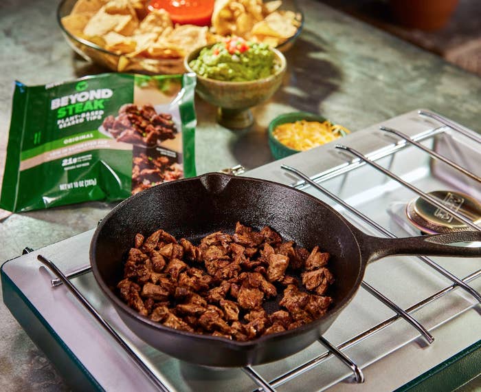 press image of beyond steak in a cast iron skillet being used with nachos